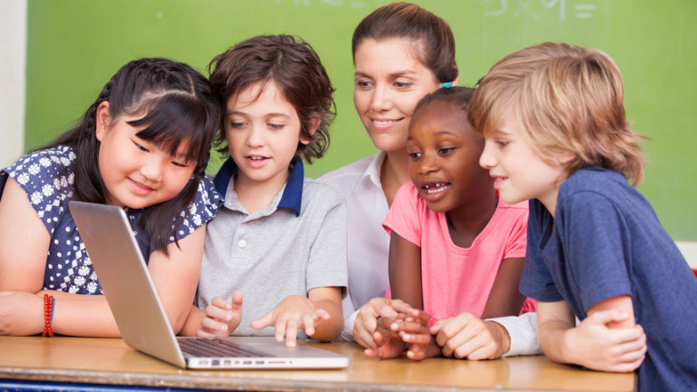 Chidlren gathered around a laptop computer