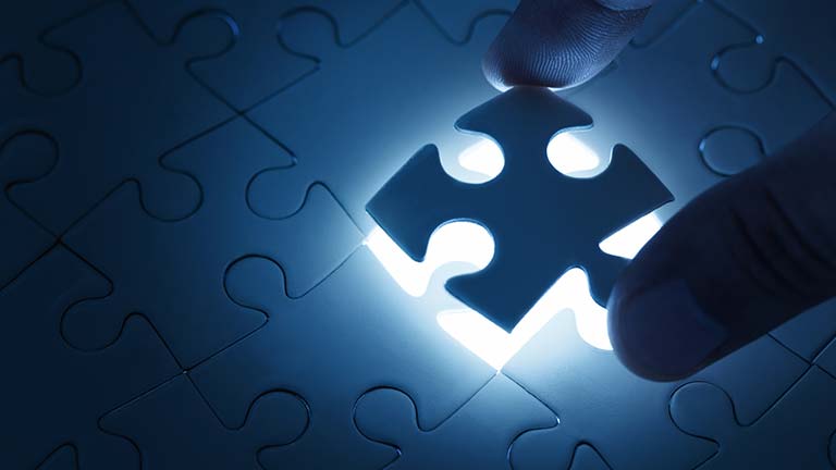 Close up of a person placing a puzzle piece