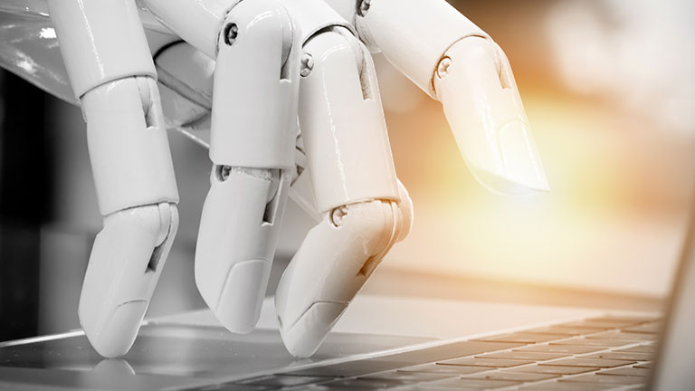 Robotic hand touching laptop keyboard