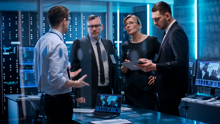 A group of colleagues working in a computer security room having a discussion