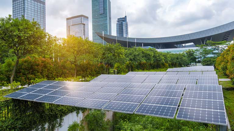 Solar panels providing an alternate power source with the city skyline they are powering in the background