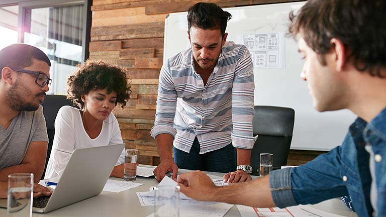 group of young people at office table discussing project