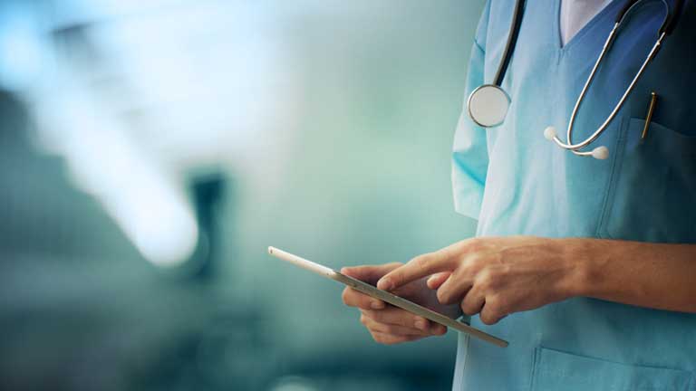 Physician using a tablet to record patient information